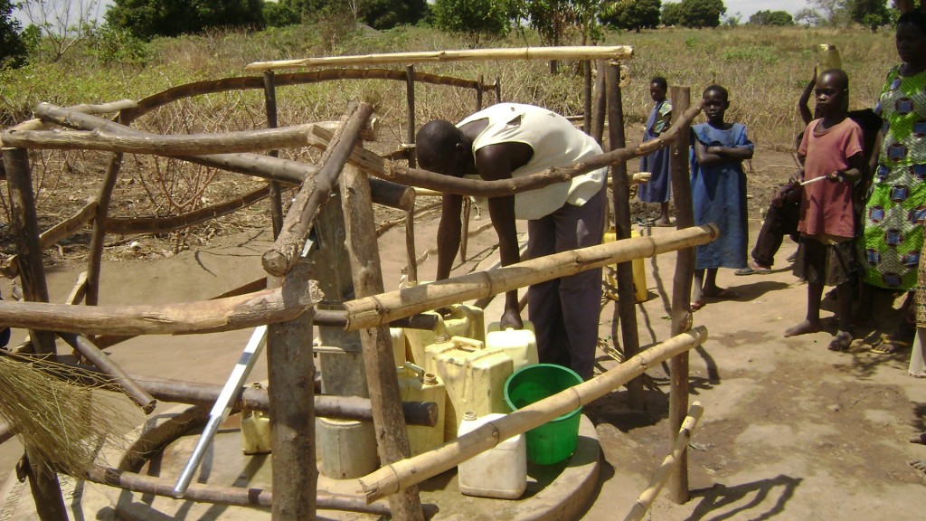 Ogwal Olule organising Jerricans at the source.